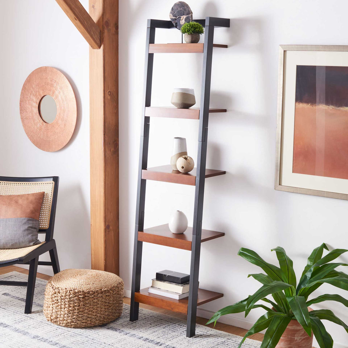 Honey-brown shelves on a charcoal frame display books and accents beside a lounge chair.