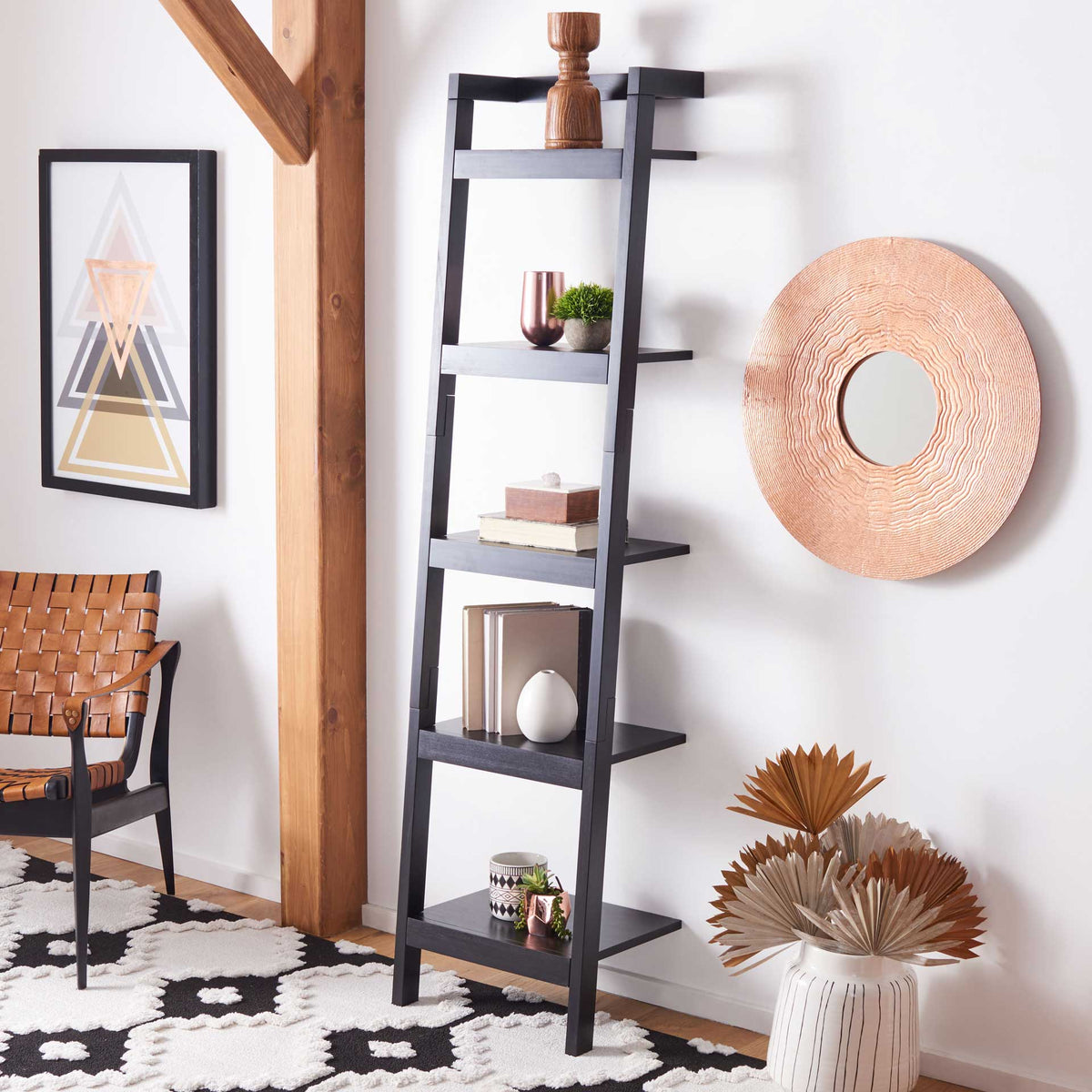 Five black shelves hold books and decor against a wall, adding vertical storage to a living space.