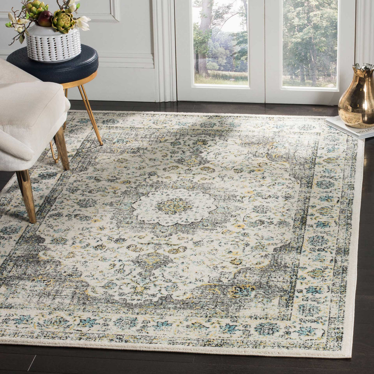 A distressed gray and gold medallion rug lends warmth to a bright sitting room