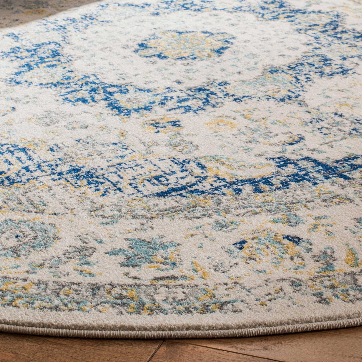 Deep blue floral motifs and soft gold accents enliven the ivory pile and curved bound edge.