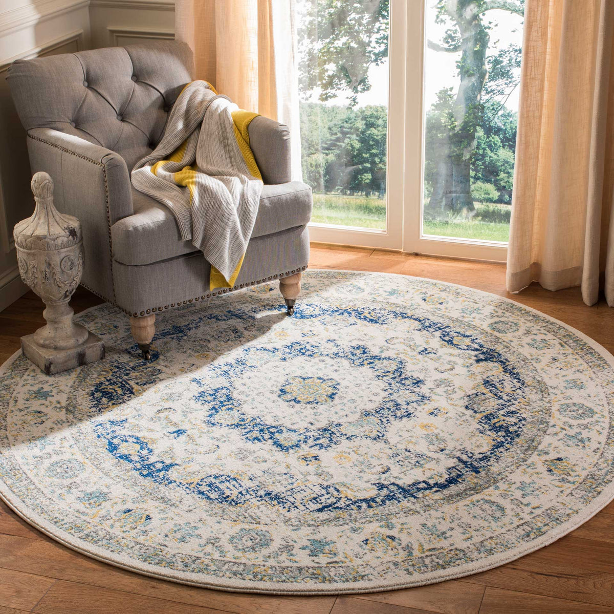 A blue floral medallion and delicate border add color and pattern to this ivory round rug.