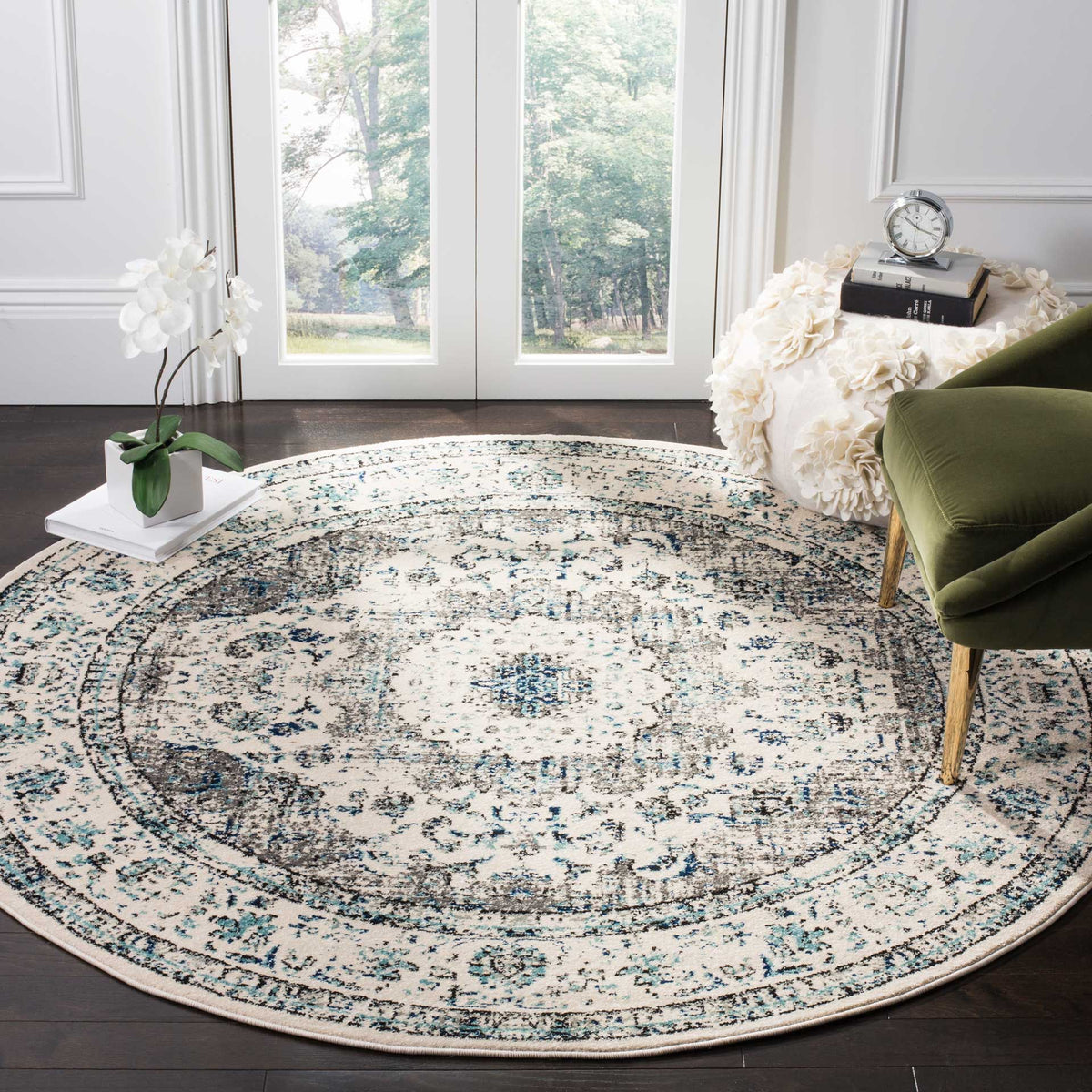 Ornate gray and blue motifs form a circular medallion that anchors this ivory round rug.