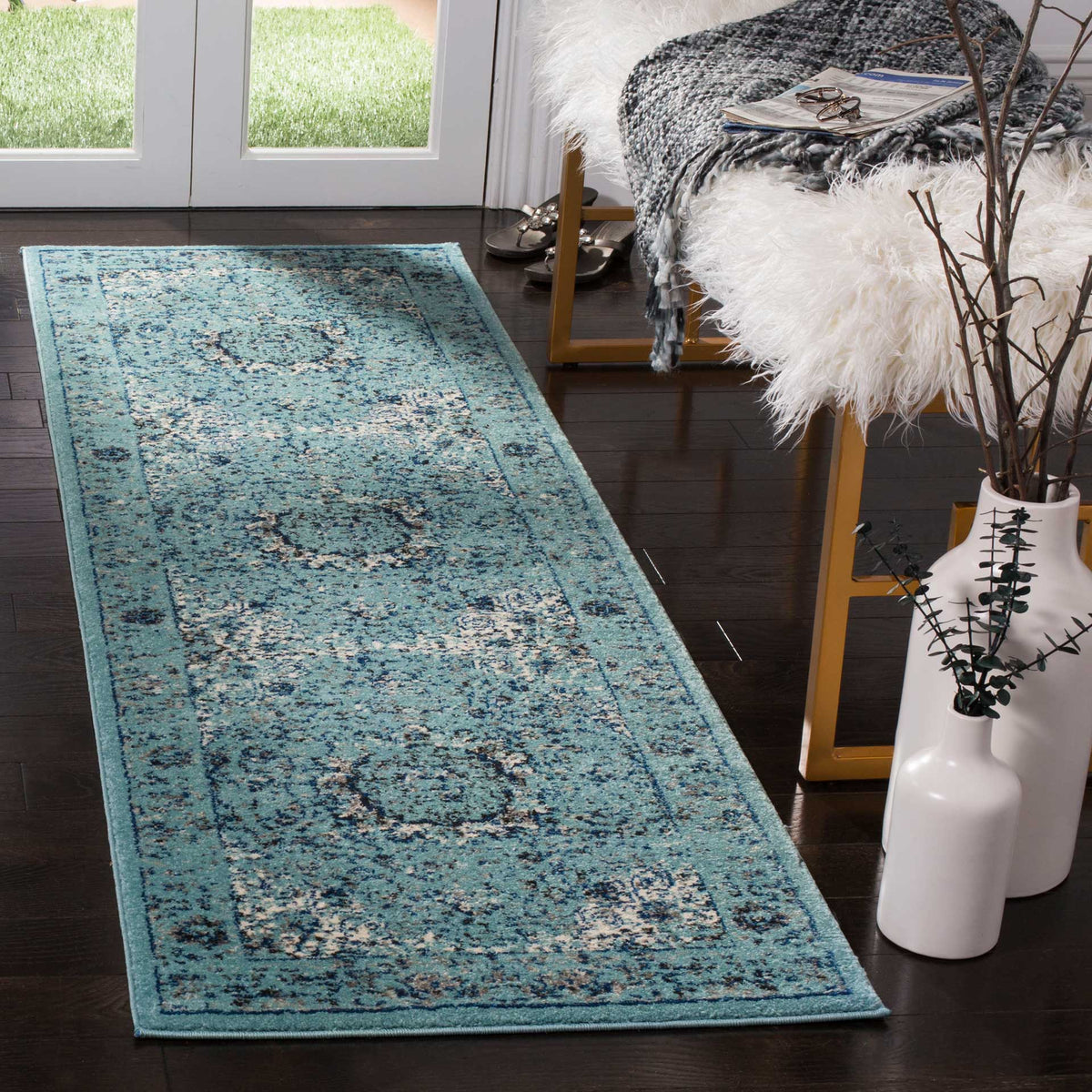A cool blue runner blends weathered floral motifs with a traditional framed pattern