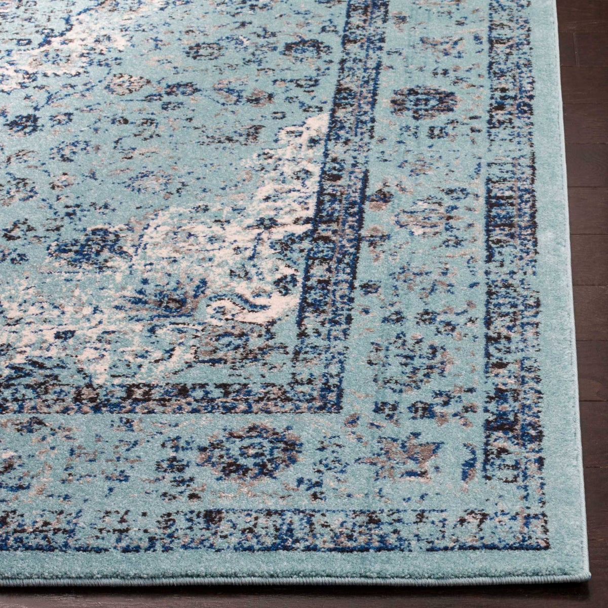 Aqua blue rug pairs weathered navy motifs with a crisp, solid-color binding