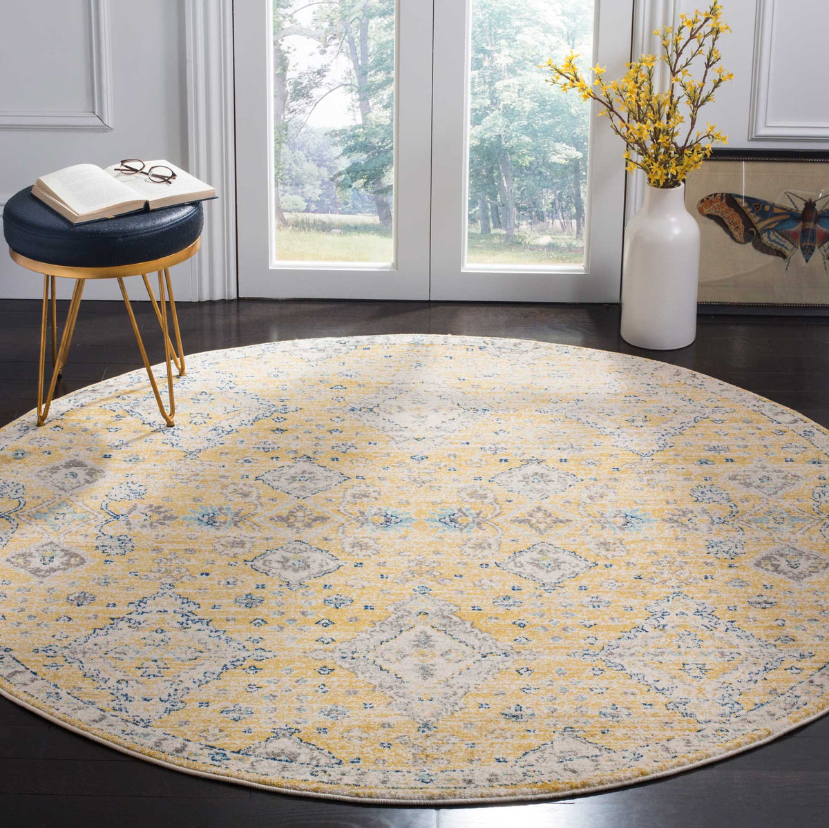 Gold and ivory round rug brings an ornate, softly faded pattern to dark wood floors