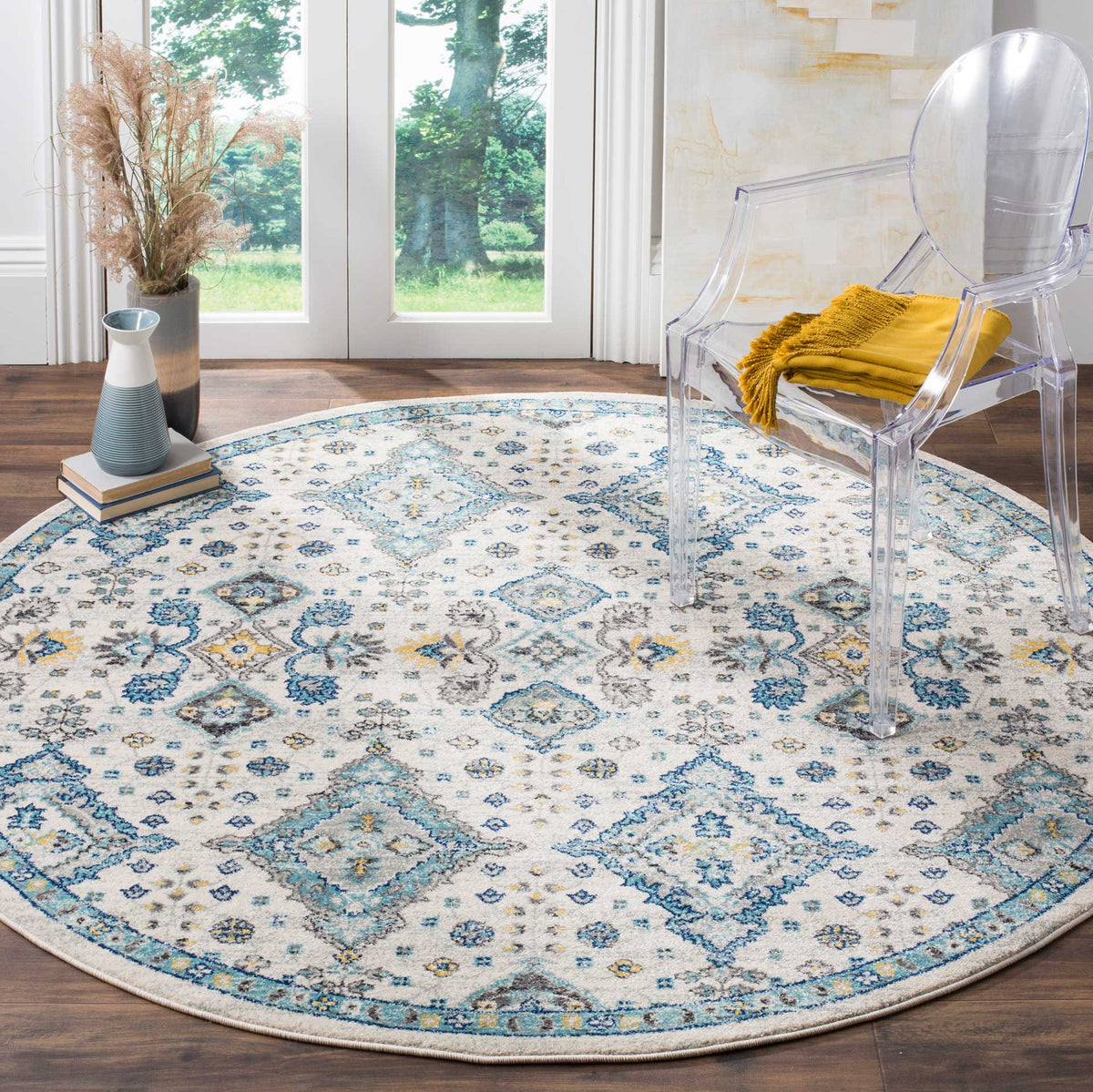 Ivory round rug pairs vivid blue medallions with subtle gold accents and an ornate border