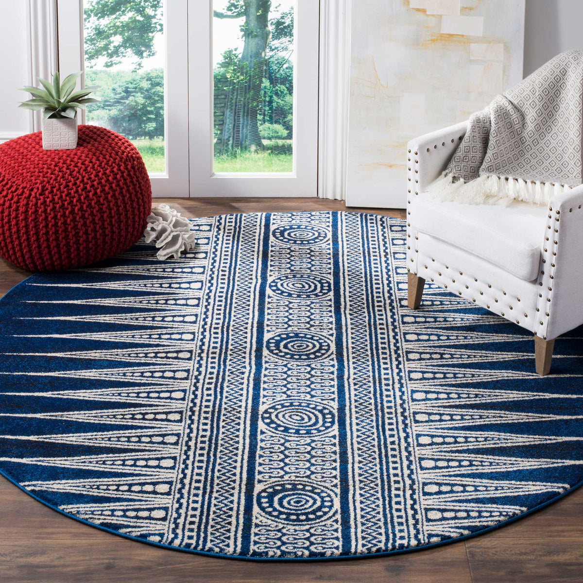 A royal blue and ivory round rug adds graphic contrast and patterned warmth to a bright sitting area