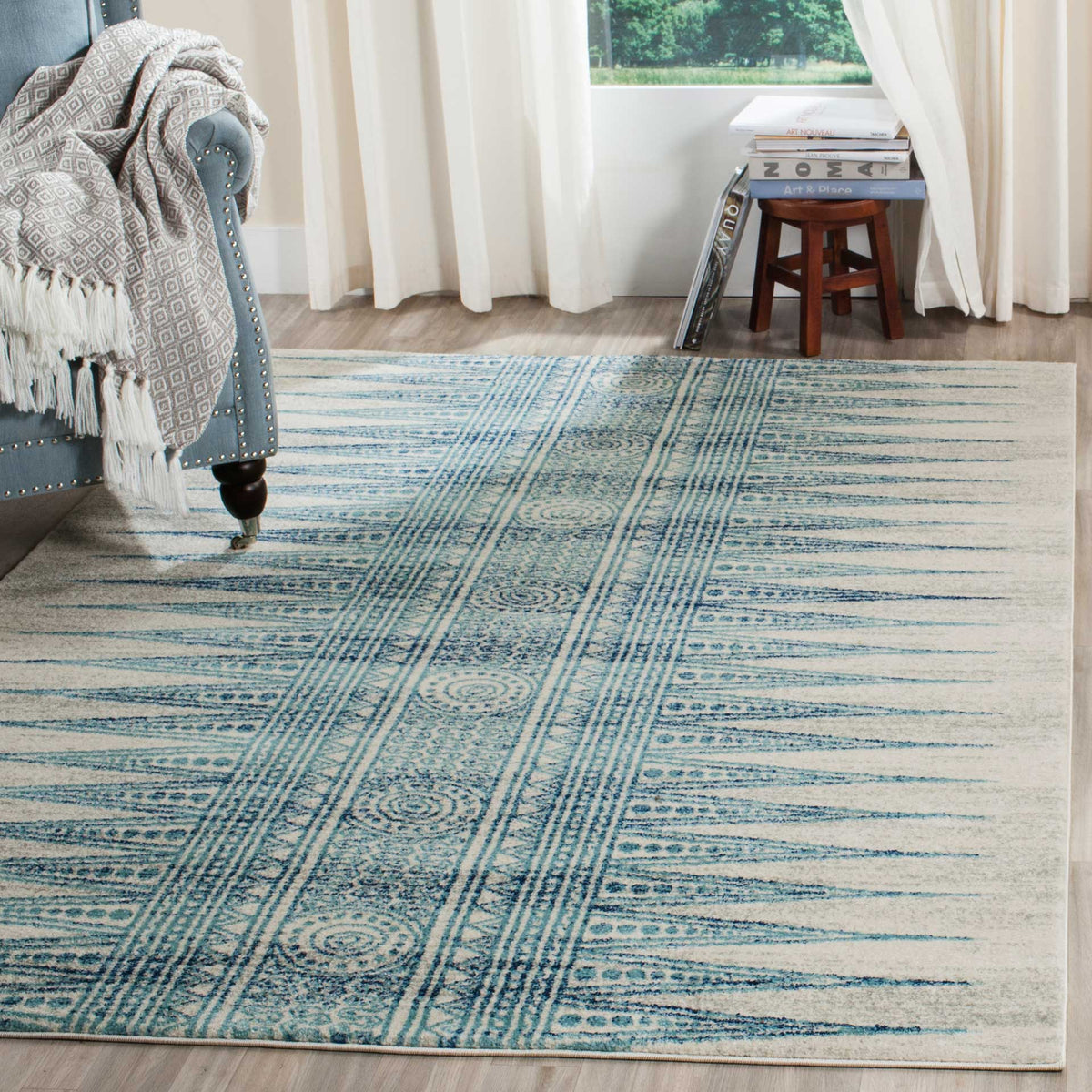 Ivory and turquoise geometric rug brightens a seating area with blue accents.