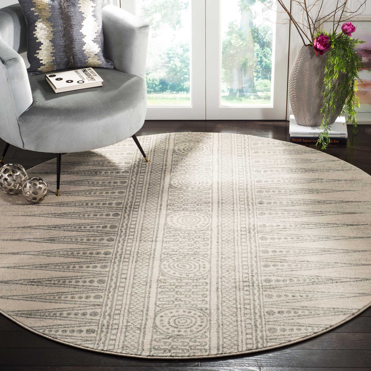 An ivory and silver round rug grounds a seating area with soft geometric patterning