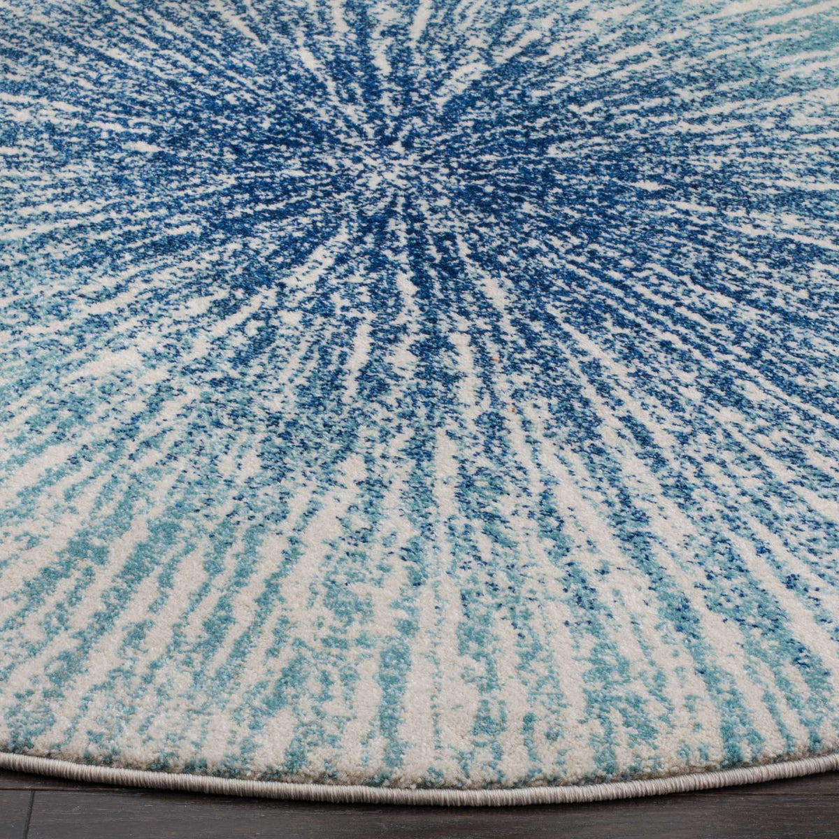 Deep blue streaks blend into soft aqua across textured pile with a bound edge