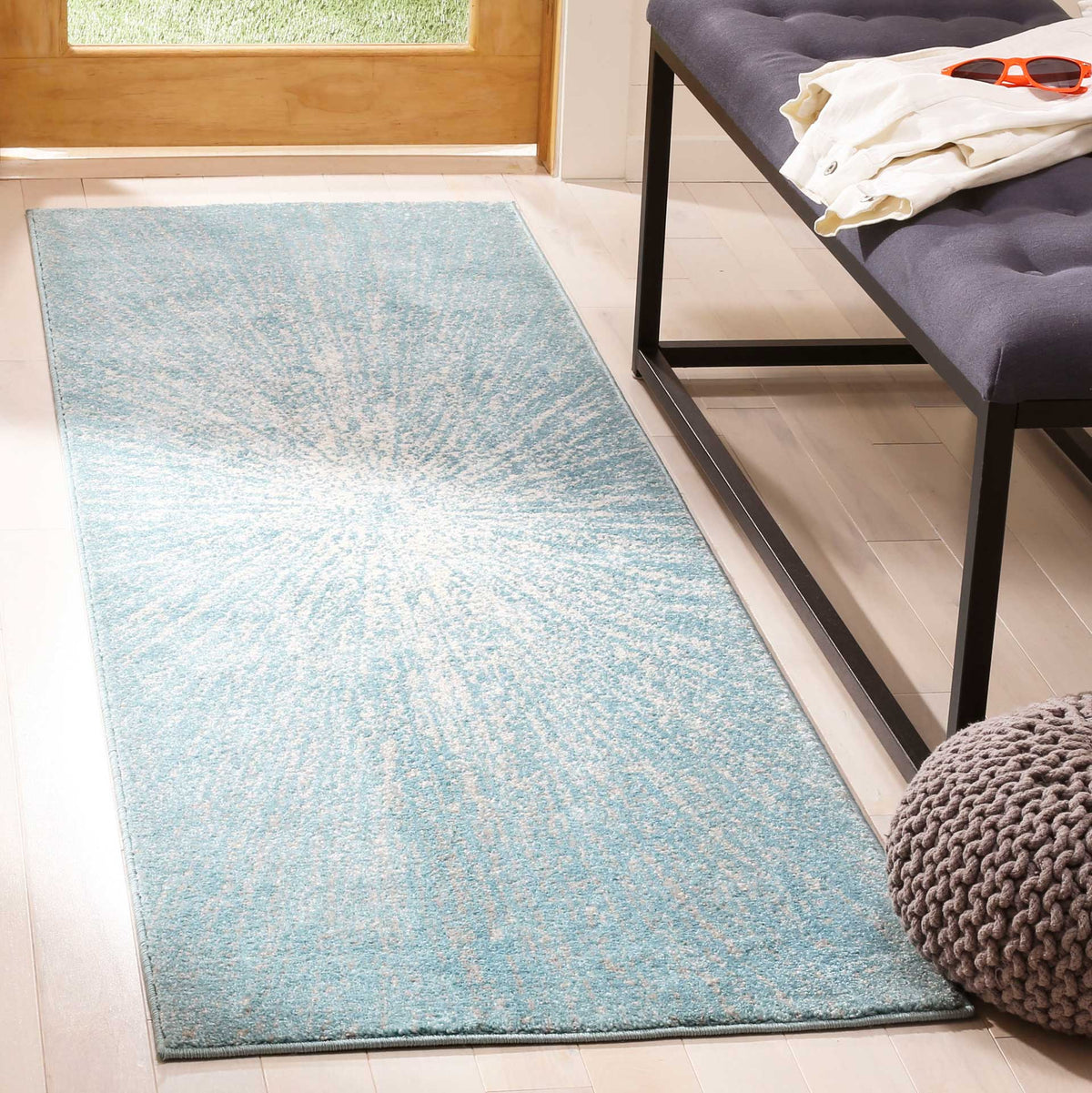 Soft aqua tones and an ivory burst add a fresh accent to this narrow runner rug.