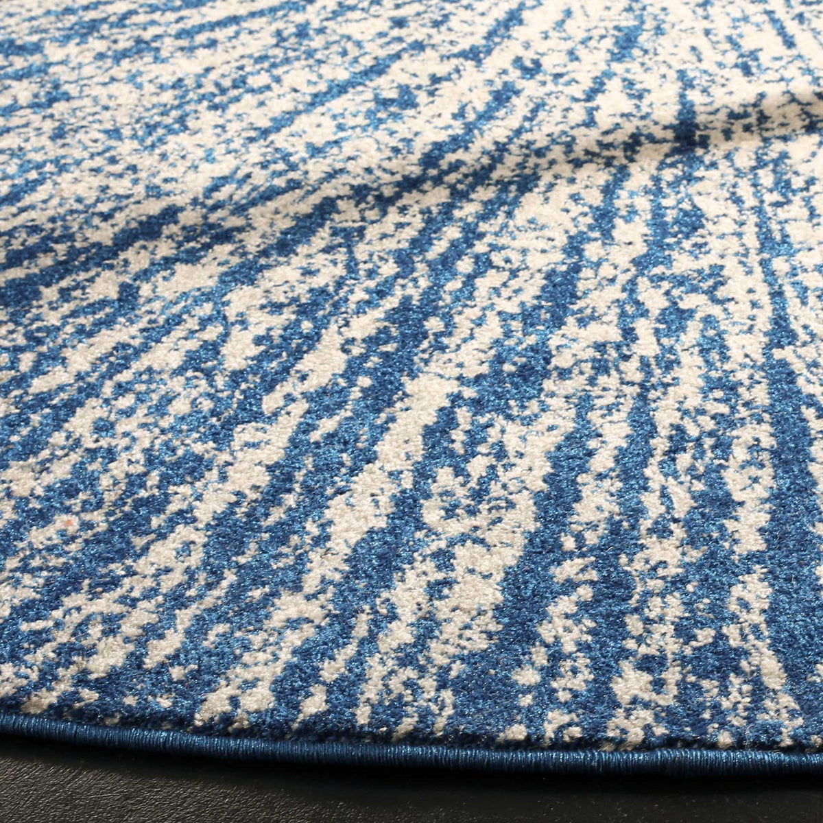 Closely spaced navy and ivory streaks highlight textured pile and a bound edge