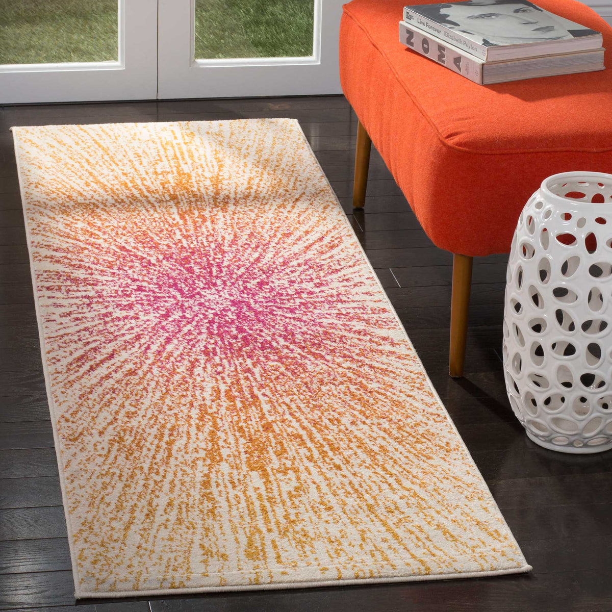 Pink rays radiate through warm orange and cream across this modern runner rug.