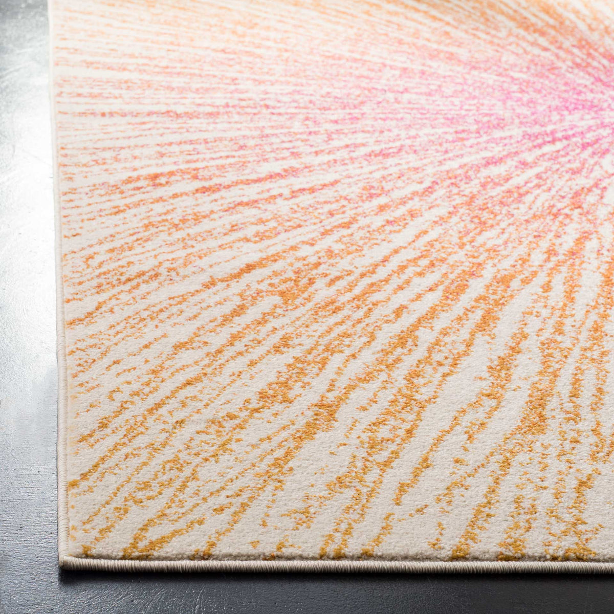 A bound cream edge frames the finely textured fuchsia and orange starburst pattern.