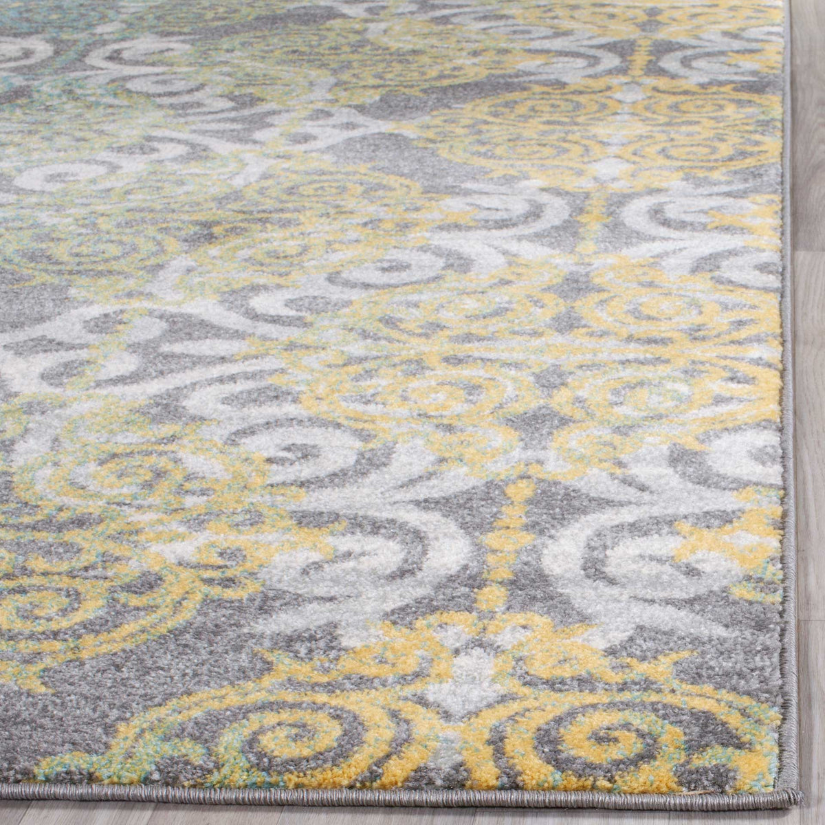 Golden scrolls and soft gray-and-ivory pile meet neatly bound rug edges.