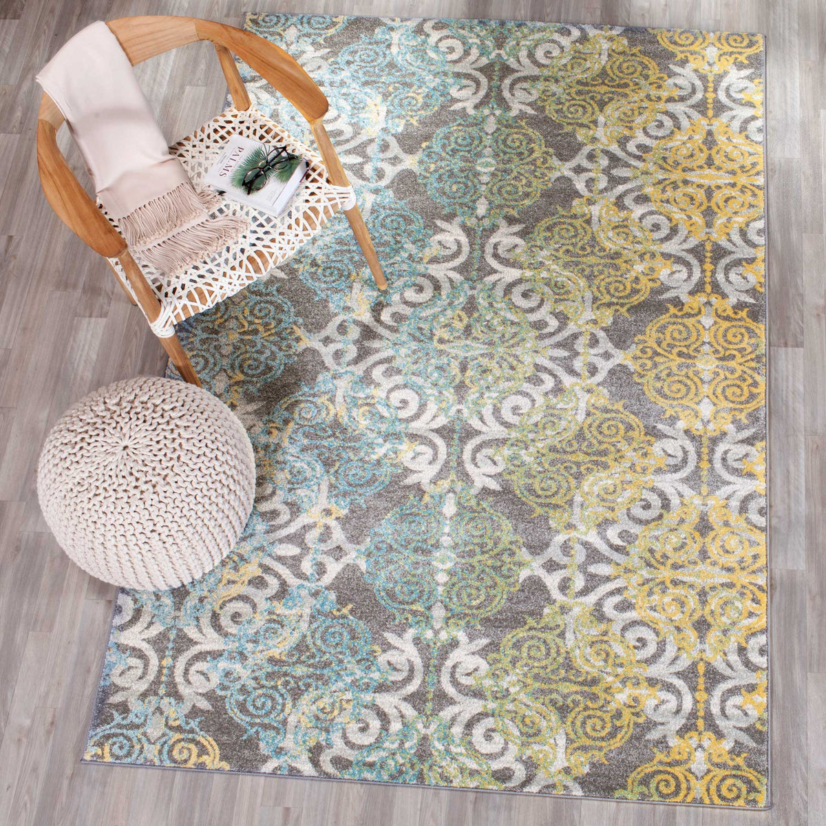 Teal and gold medallions bring color to a gray rug beside a curved wood chair.