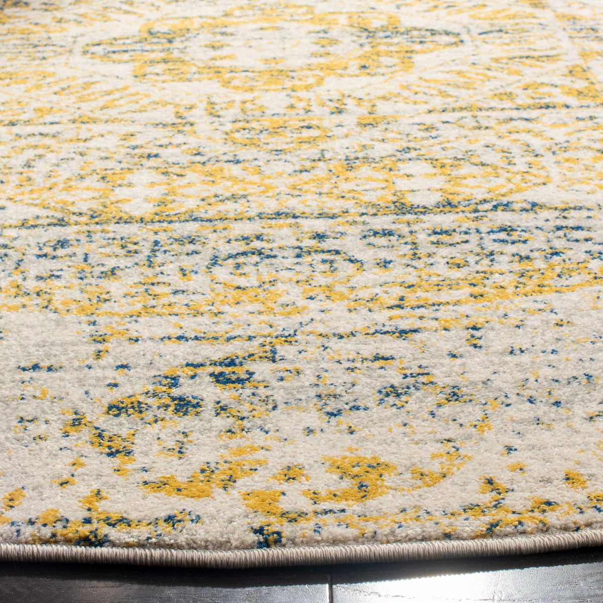 Blue and golden-yellow accents enrich the ivory rug, finished with a neatly bound edge.