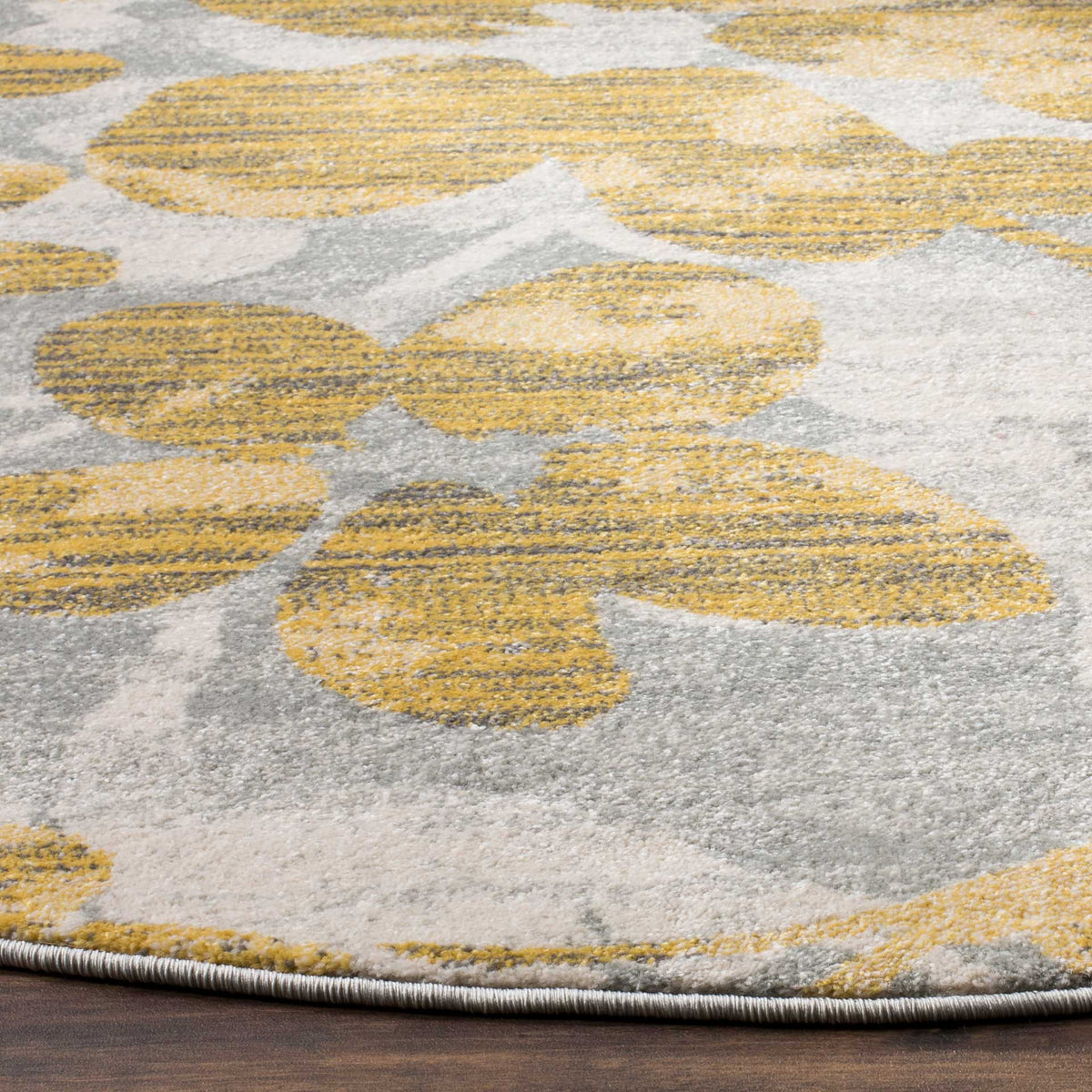 Gold floral details stand out against mottled gray pile and a neatly bound edge