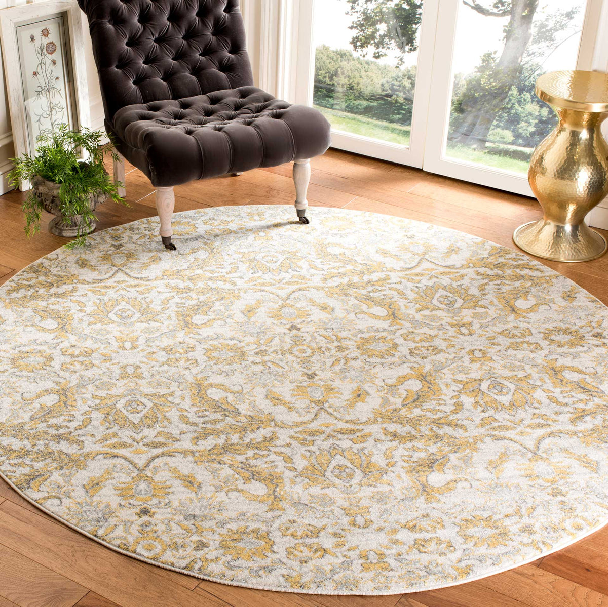 Ivory and gold floral detailing gives this round rug a bright, elegant foundation for living spaces