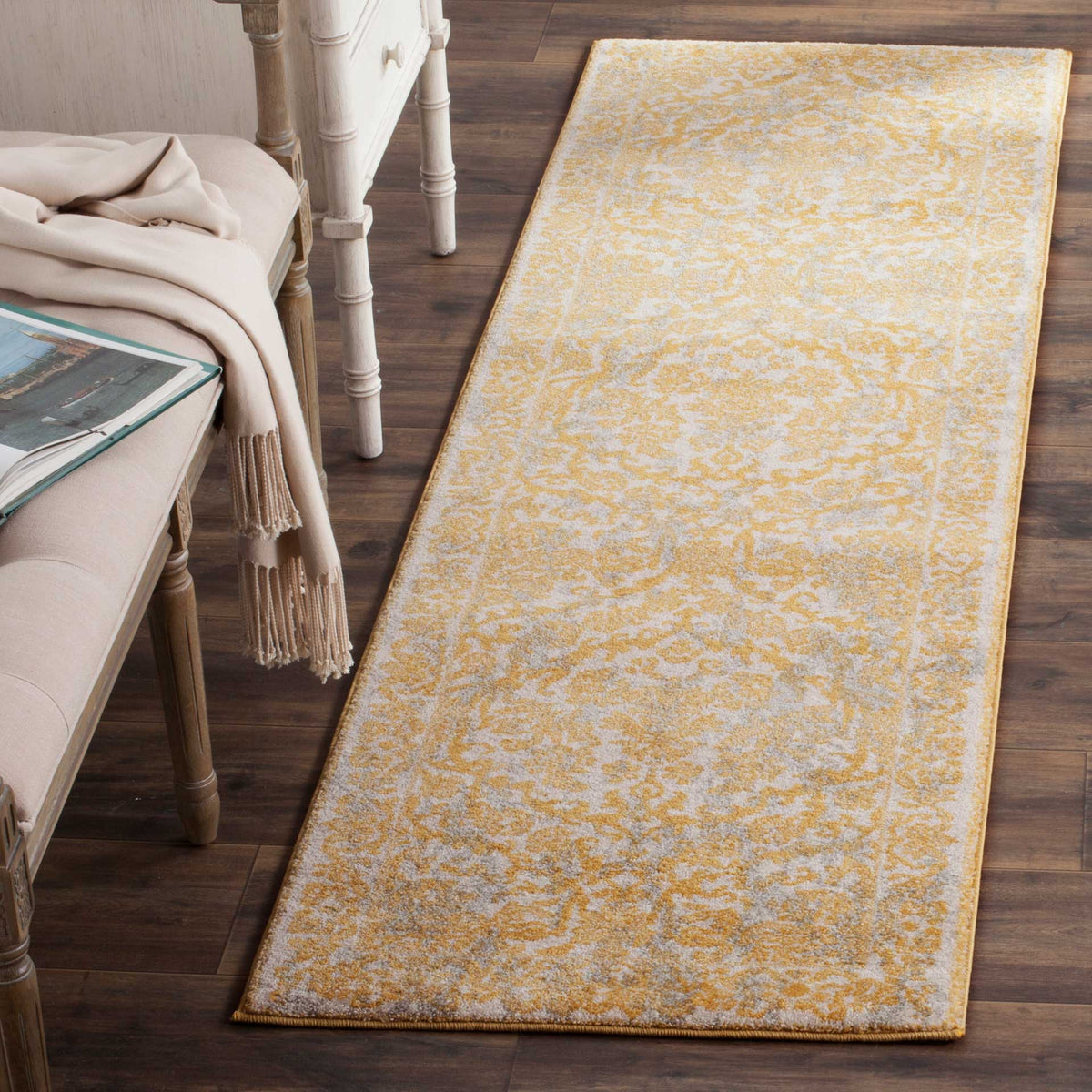 Slim ivory and gold runner rug with a faded floral design that adds warmth to narrow spaces