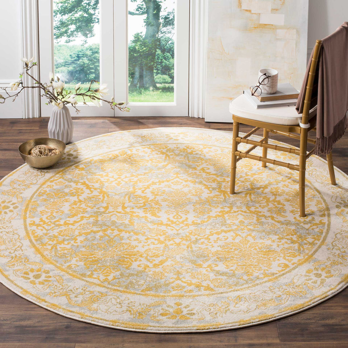 An ivory and gold floral rug adds warmth and intricate pattern beneath an accent chair.