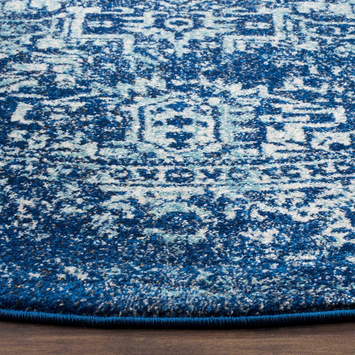 Navy and ivory motifs bring vivid contrast to the textured pile and blue bound edge.