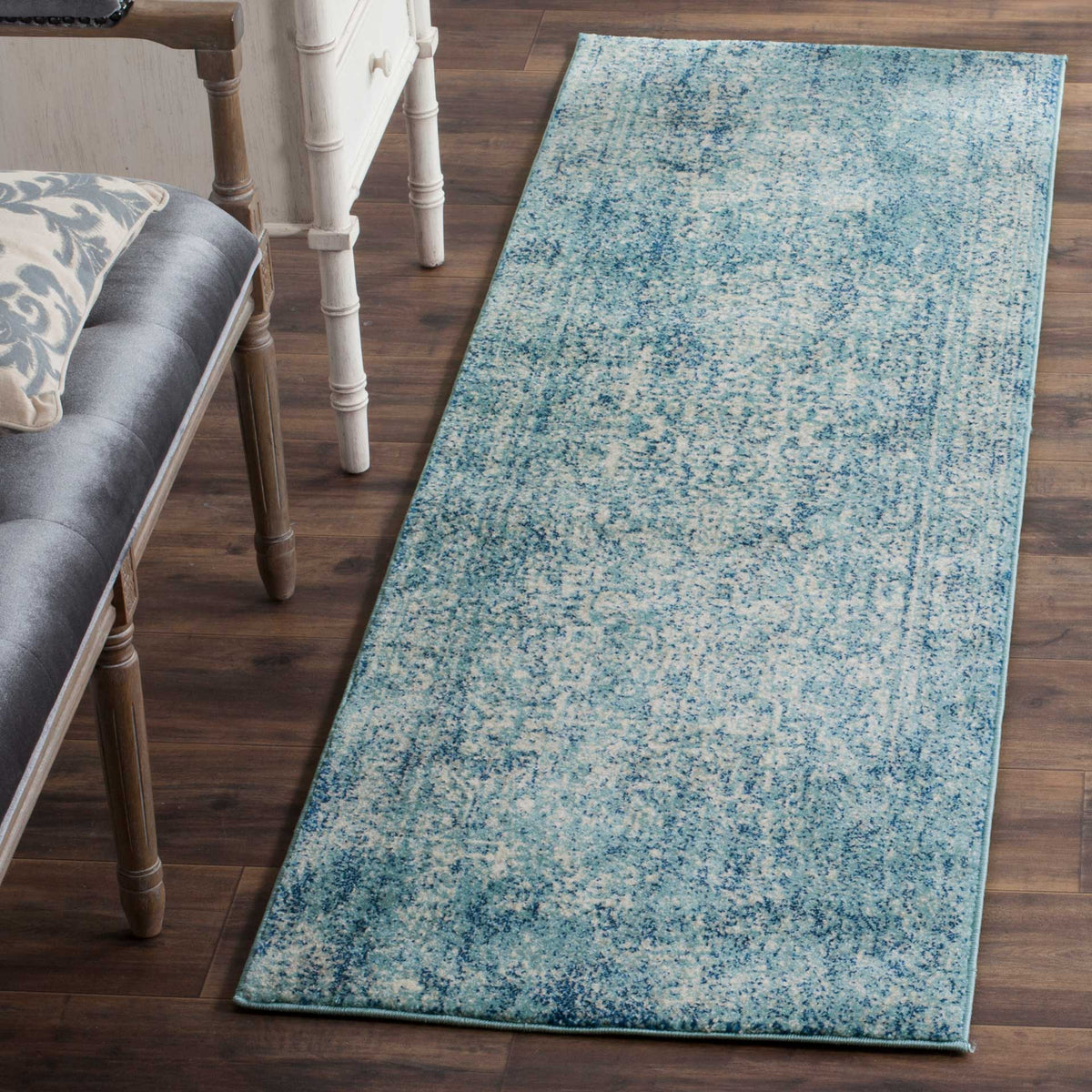 Blue and ivory runner adds soft color and vintage detail beside upholstered seating