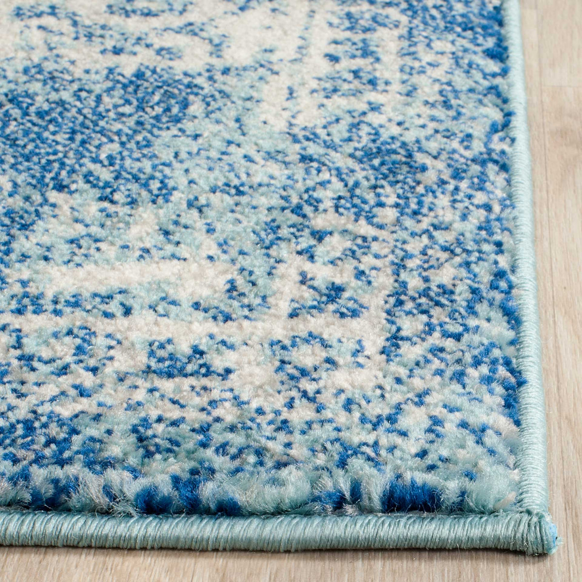Variegated blue and ivory fibers create a plush look above a tidy woven border
