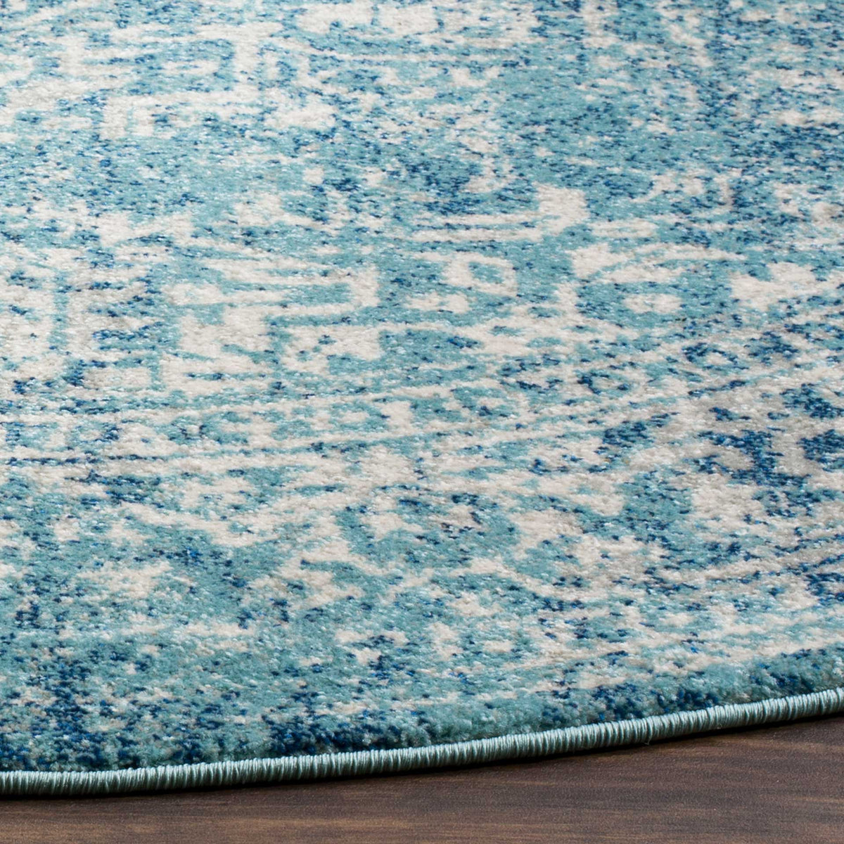 Blue and ivory floral motifs reveal a textured pile and neatly bound edge.