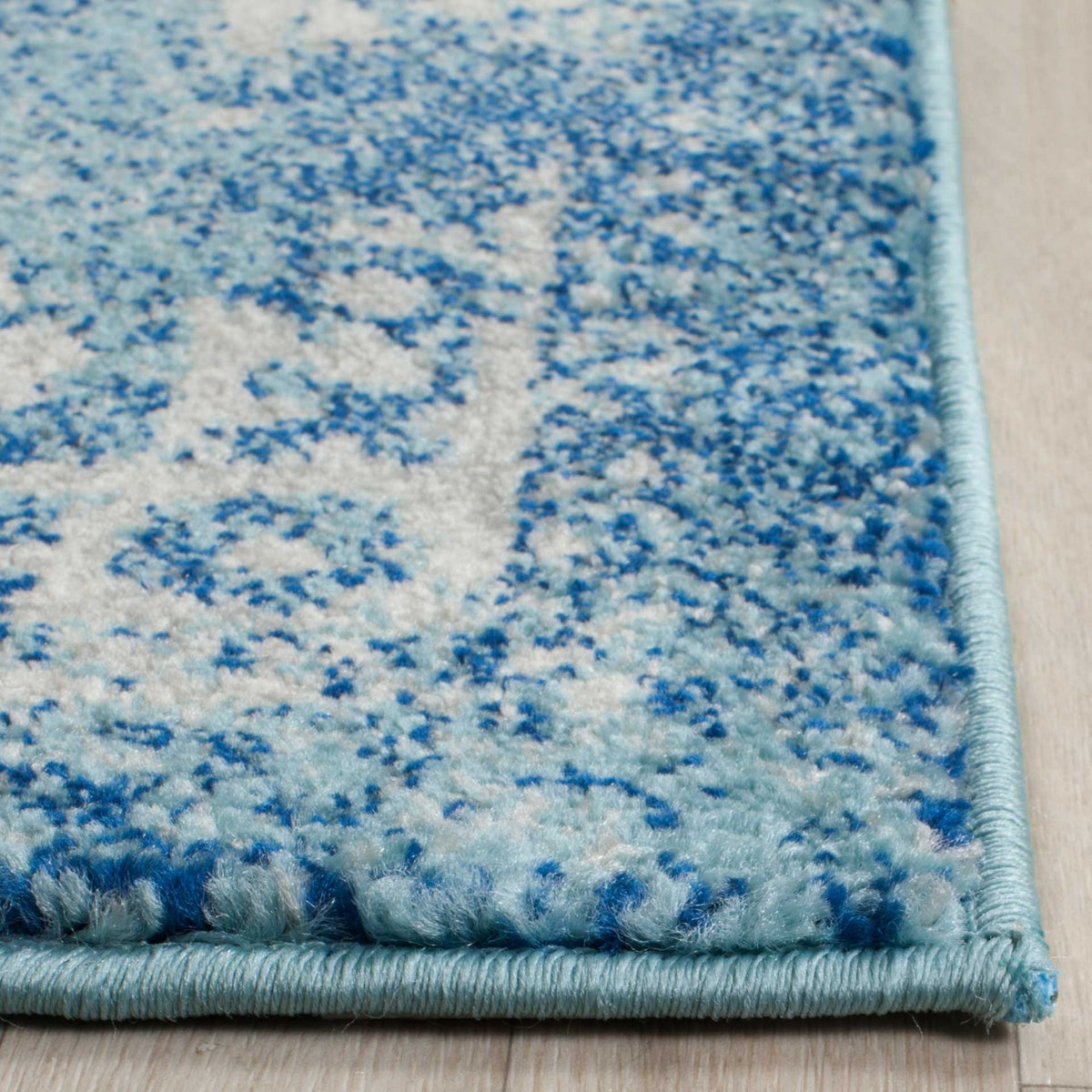 Soft blue and ivory patterned pile meets a neatly bound blue edge