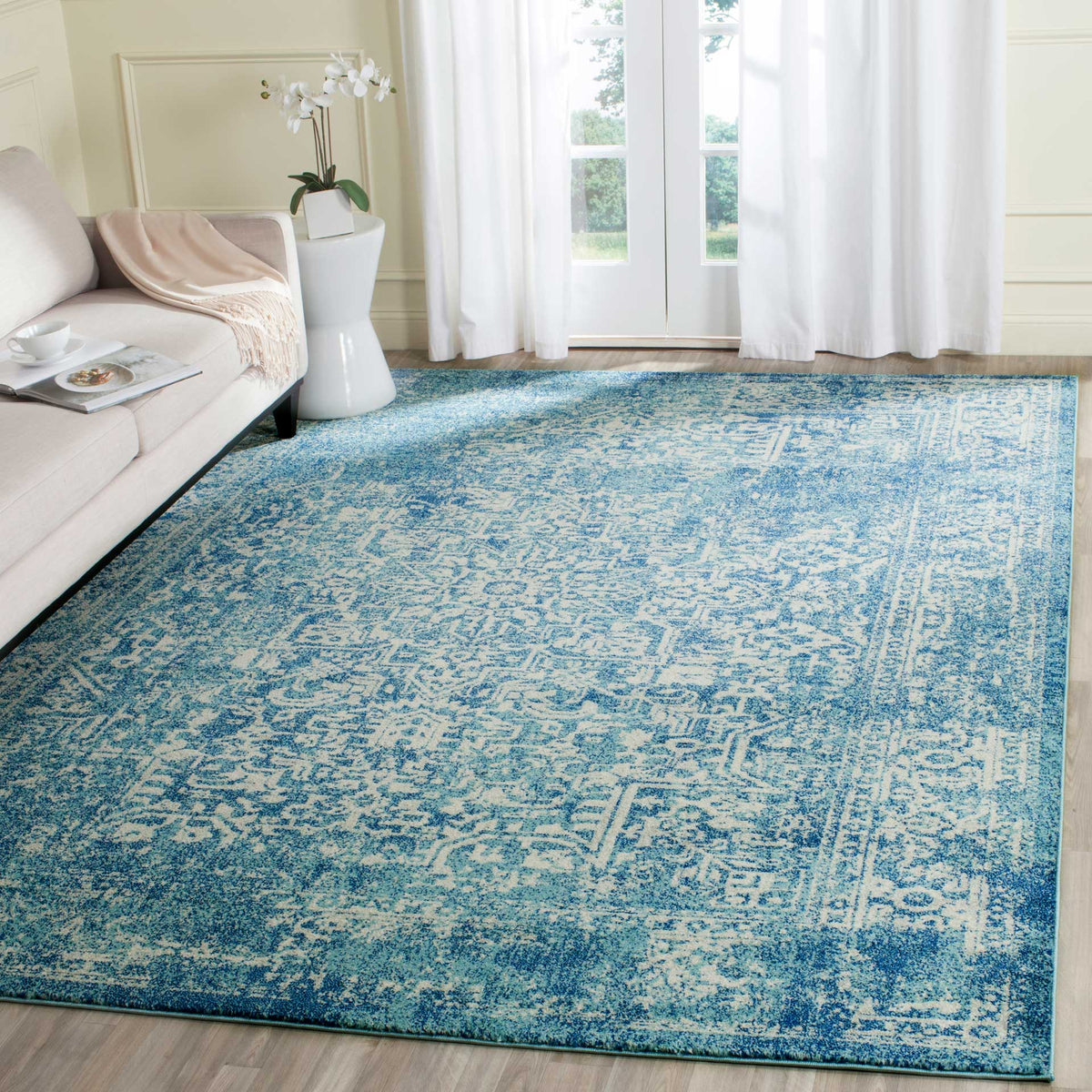 Blue and ivory medallion rug adds a bright traditional accent beside a light sofa
