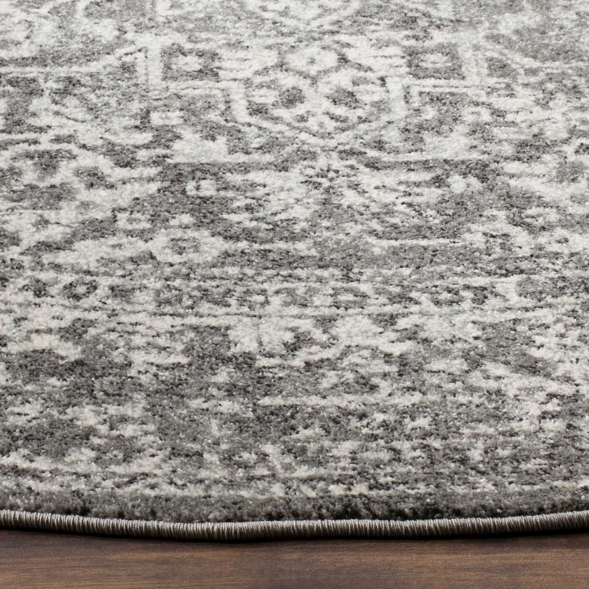 Gray and ivory patterning continues to the rug's dark bound edge.