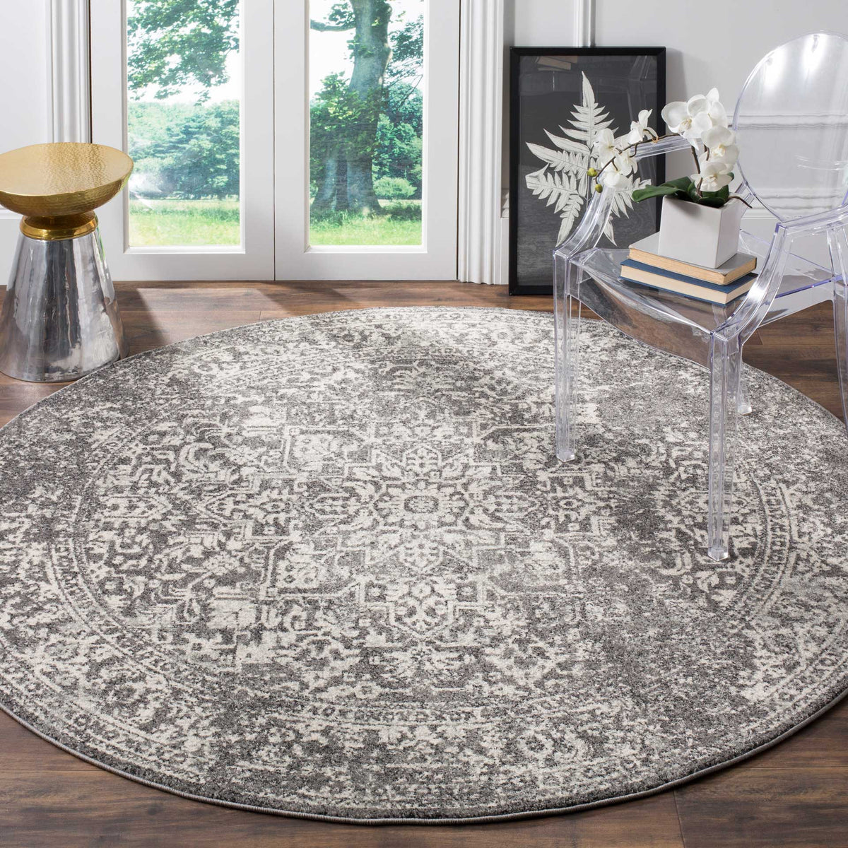A gray and ivory round rug balances a modern seating area with weathered traditional motifs.