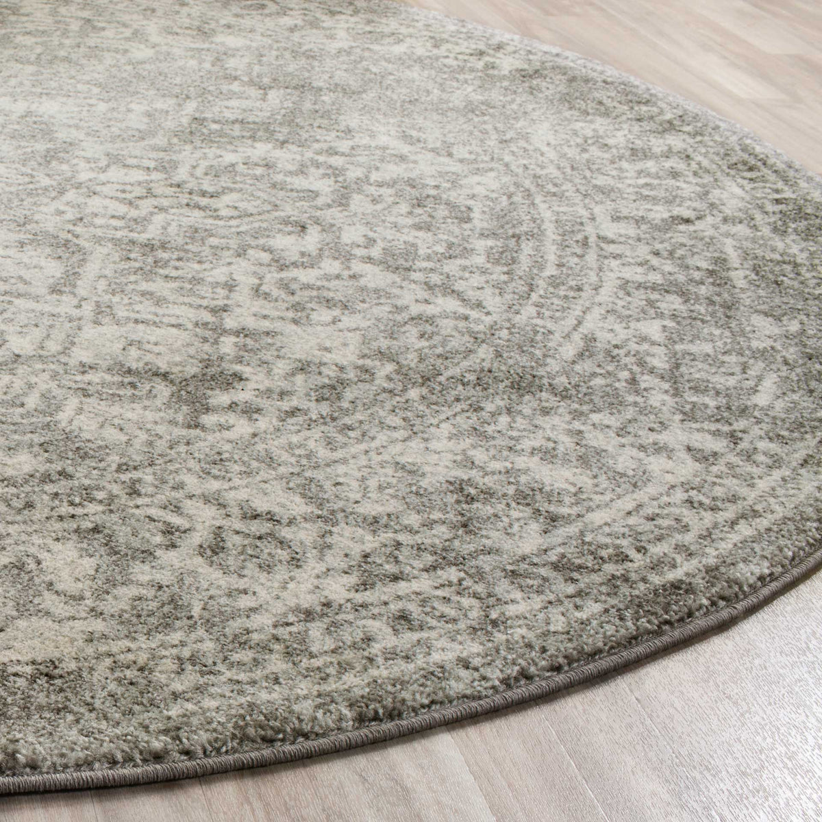 Muted silver and ivory motifs meet a gently curved edge with tidy binding.