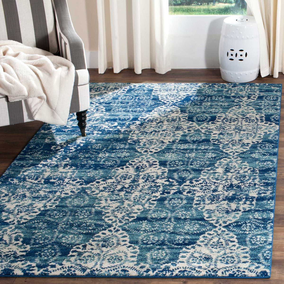 Royal blue and ivory floral rug brings inviting contrast to a seating area with wood floors