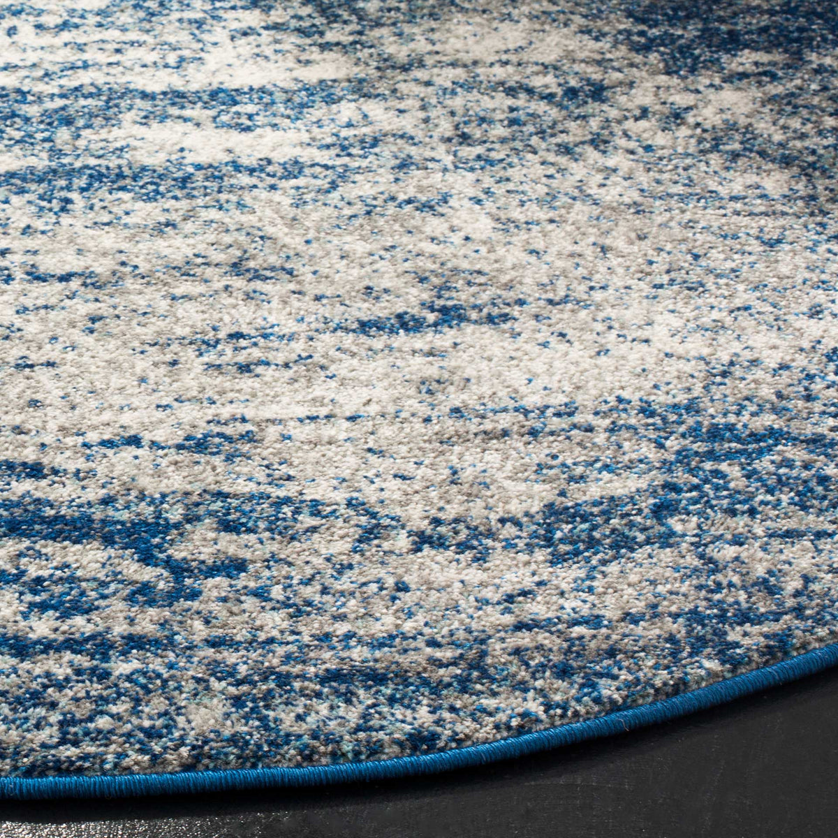 Deep blue binding frames a textured pile in mottled navy and ivory.
