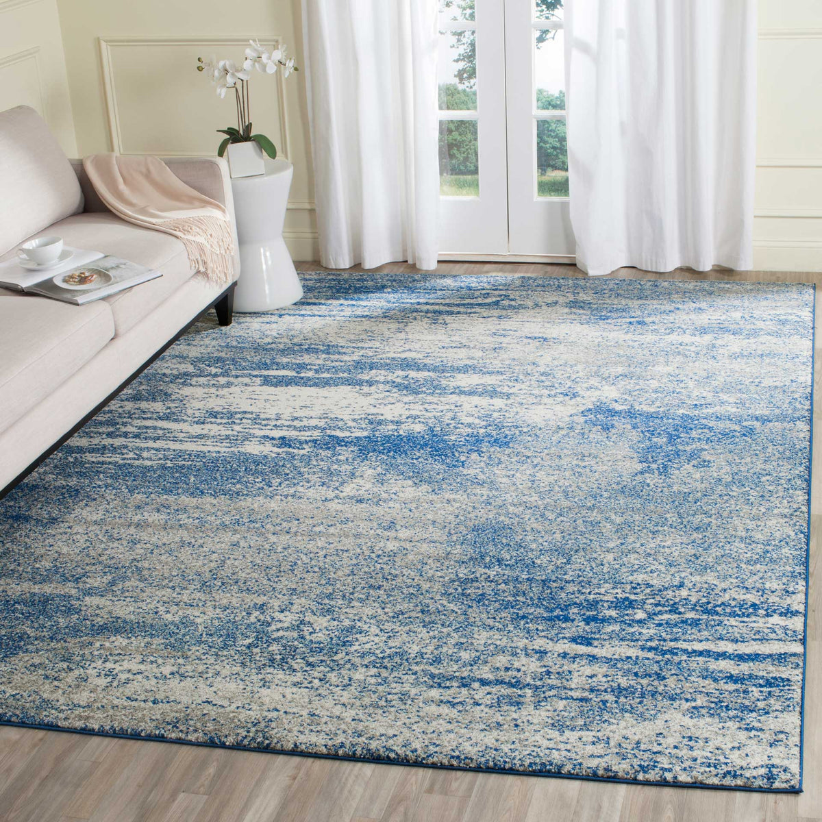 A navy and ivory rug grounds the living space with sweeping, distressed brushstrokes.