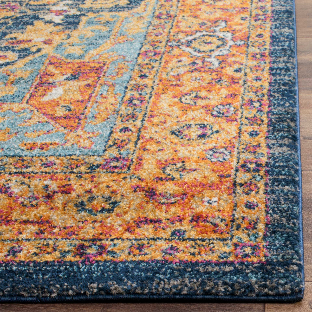 Dense orange and blue pile reveals turquoise tracery and a neatly bound dark edge.