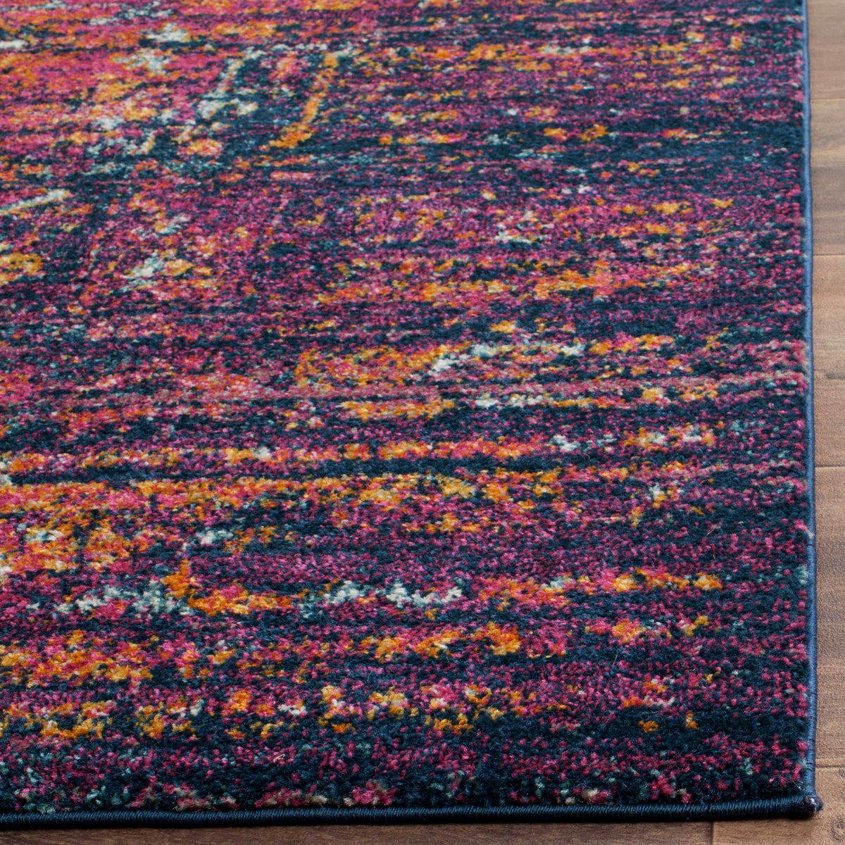 Fine variations in blue, fuchsia and gold enrich the rug's soft pile and finished edge.