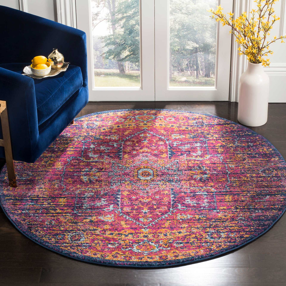 A vivid fuchsia and blue medallion anchors this round rug's weathered pattern