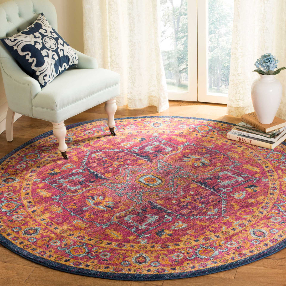 Vibrant fuchsia and orange medallion motifs brighten this round rug beneath a pale chair