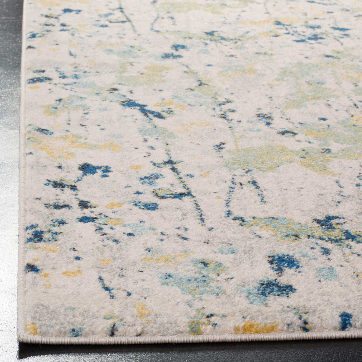 A neatly finished edge frames ivory pile with yellow dabs and blue speckles