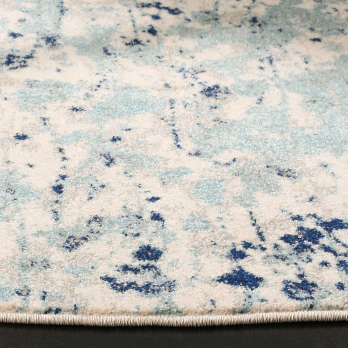 Ivory and blue pile pairs mottled navy accents with a neatly finished edge