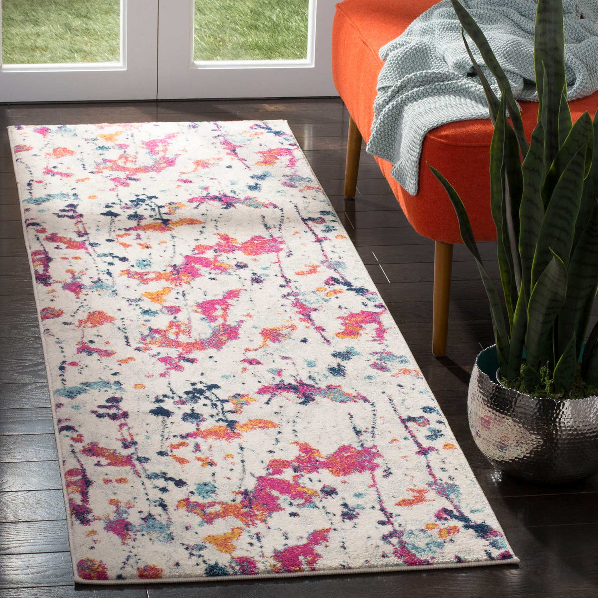 Bold pink and blue abstract accents bring energy to this ivory runner on dark flooring