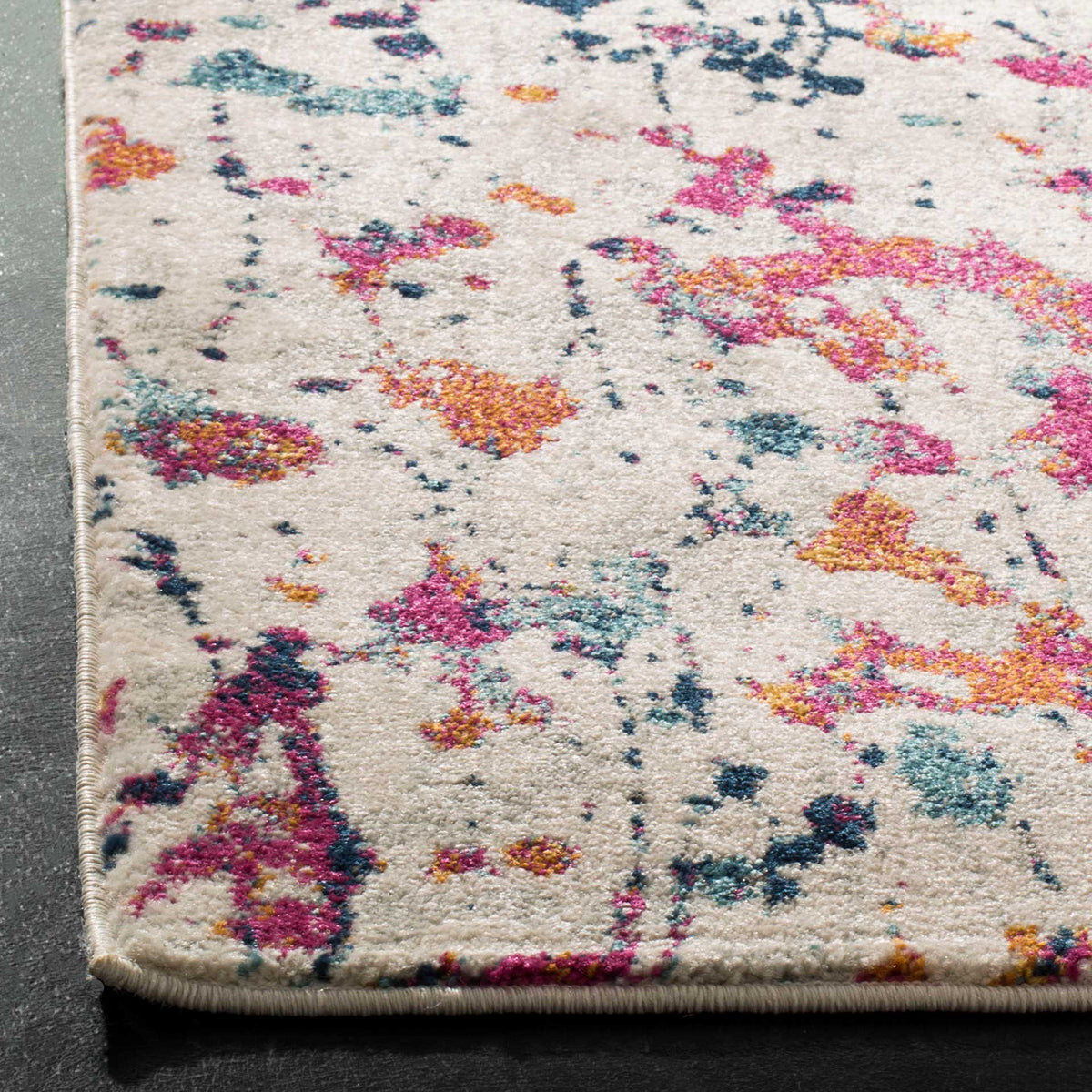 Bound edges frame soft ivory pile marked with vibrant pink, orange, and blue flecks