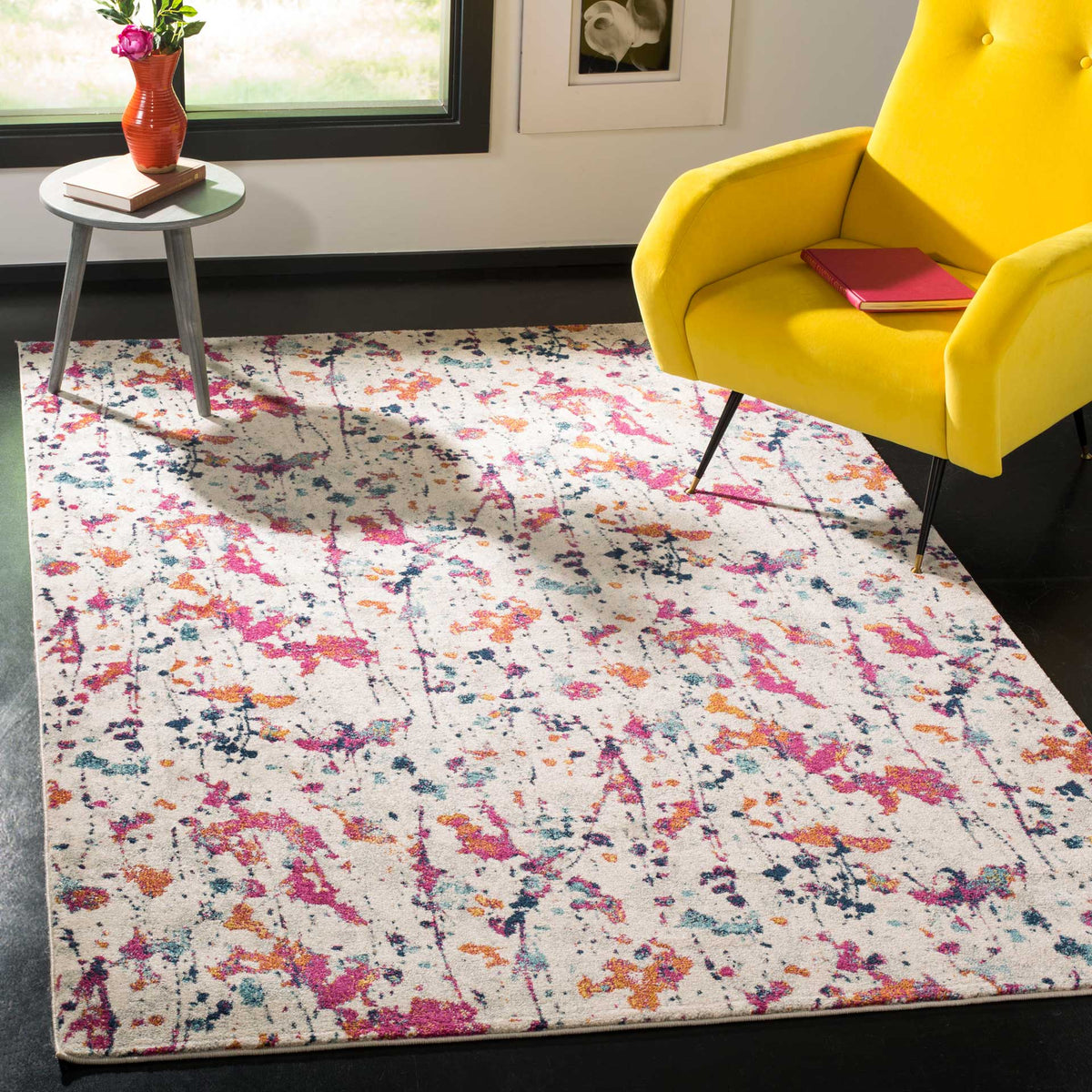 Vibrant pink and orange splashes enliven an ivory rug beneath a sunny accent chair