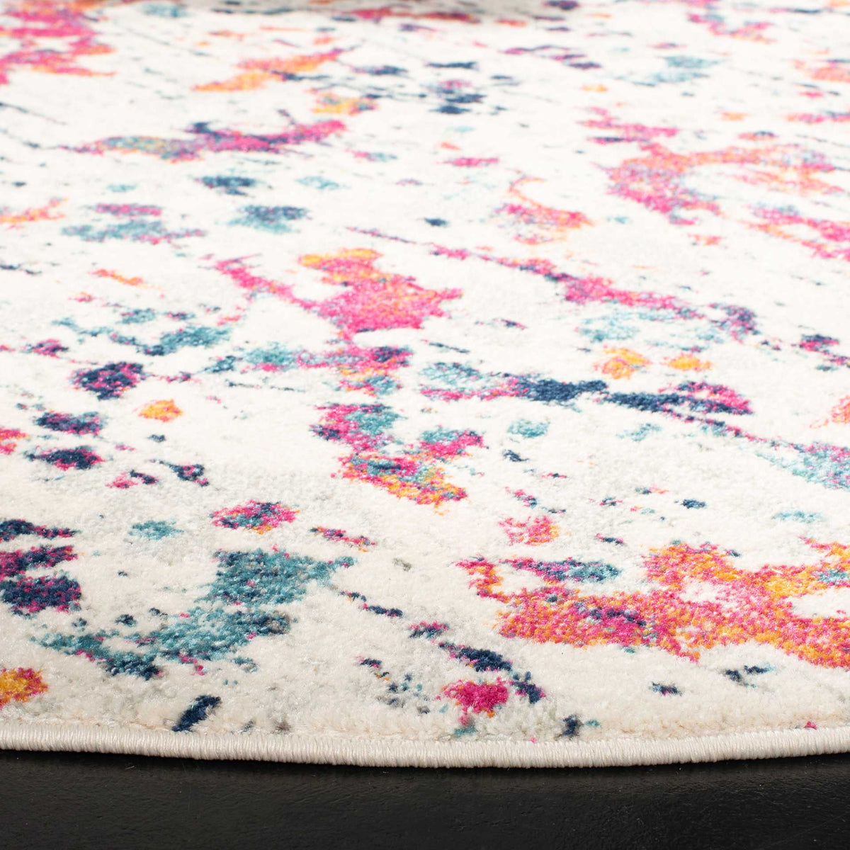 Red, pink, and blue accents enliven ivory pile with a neatly finished edge