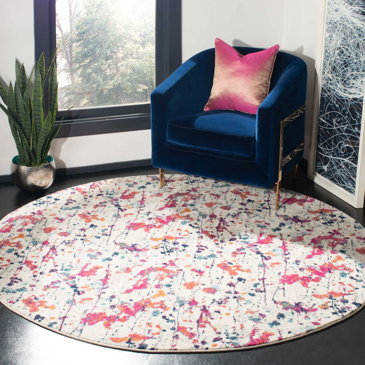 Vibrant ivory and red round rug adds playful abstract color to a cozy seating area