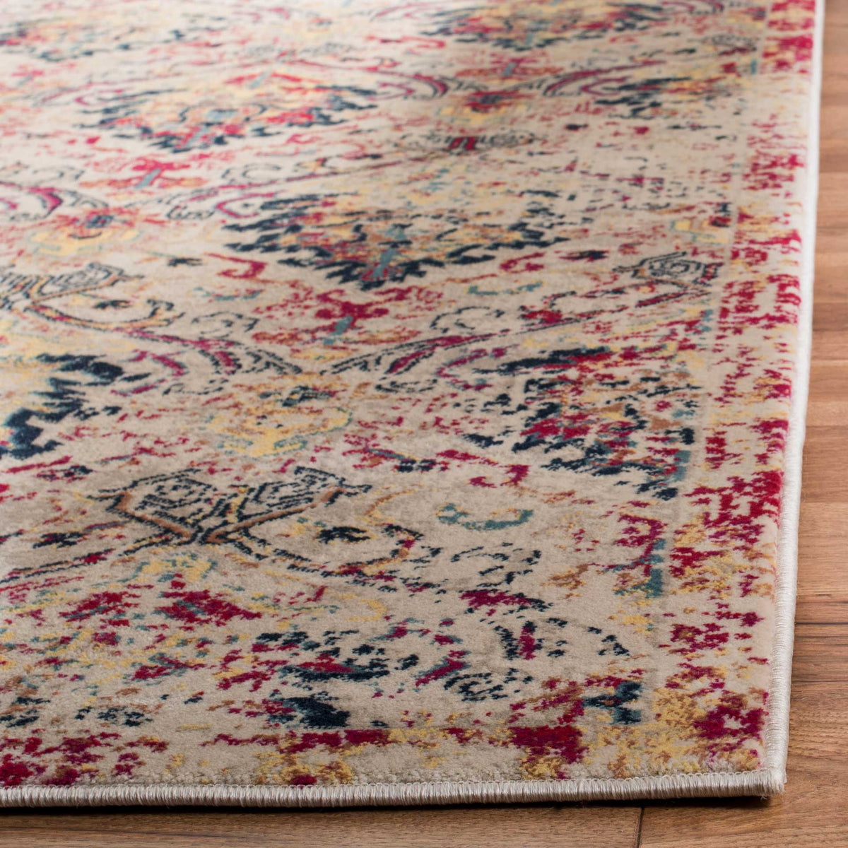 Bound edges frame the rug's textured ivory pile and richly layered fuchsia and navy motifs
