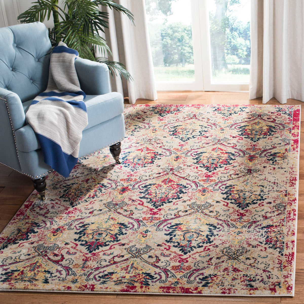Colorful medallions and a fuchsia border give this ivory rug a lively presence beside a blue chair